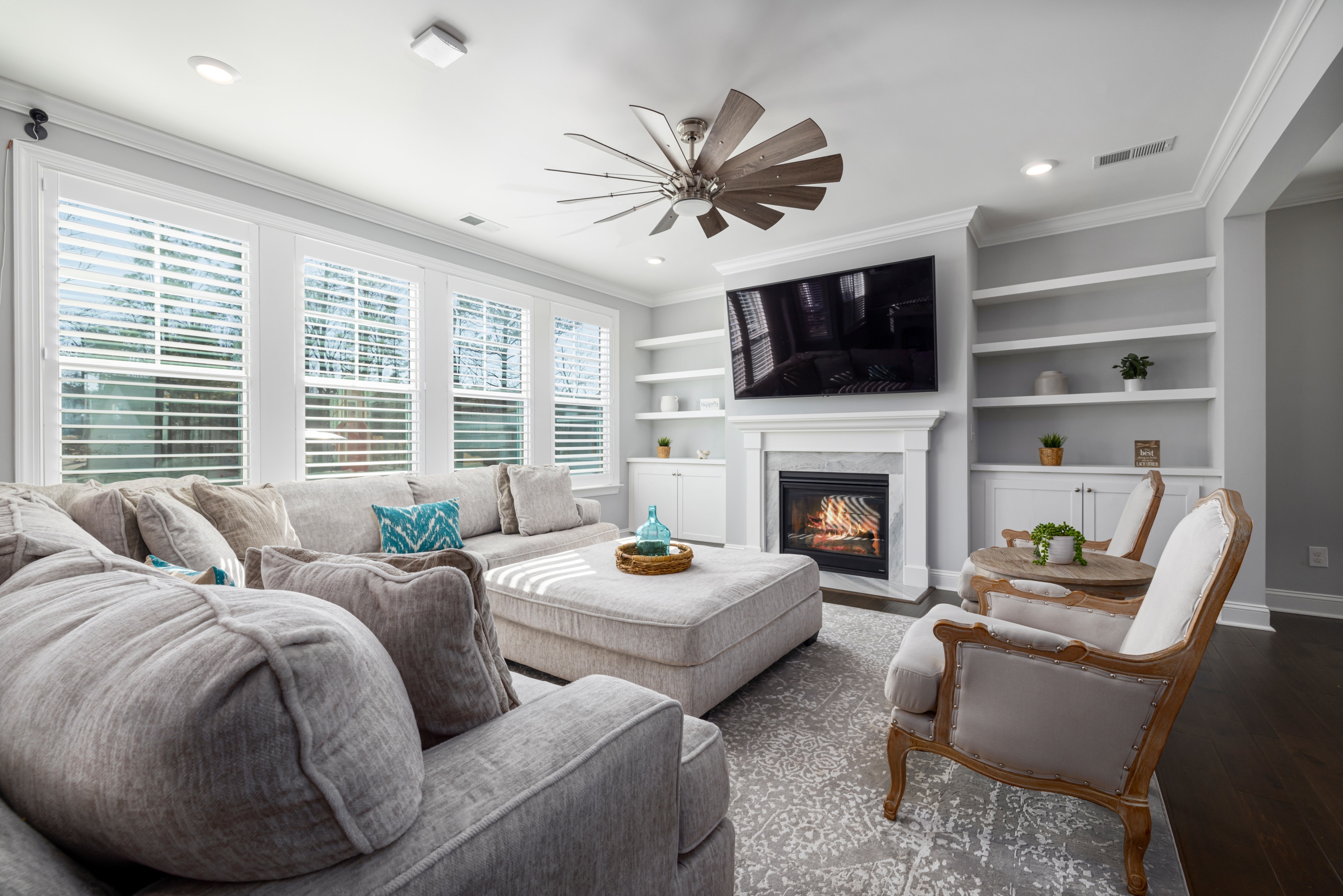 living room with gray couch ceiling fan and fireplace