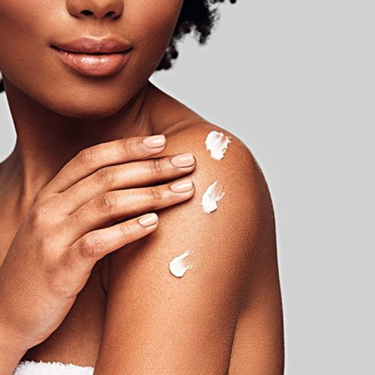 Woman putting skincare lotion on her body. 