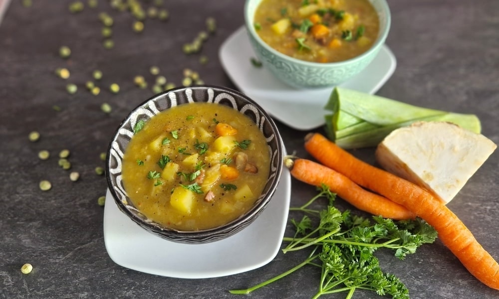 2 Schalen mit Erbsensuppe und den Zutaten daneben