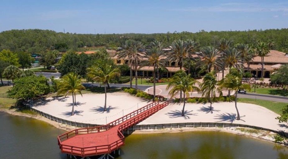 This image showcases a luxurious single-family home in Pelican Preserve, Fort Myers, featuring a stunning saltwater pool surrounded by lush tropical landscaping. The spacious pool deck creates a private tropical oasis, perfect for enjoying relaxing evenings in this resort-style community.