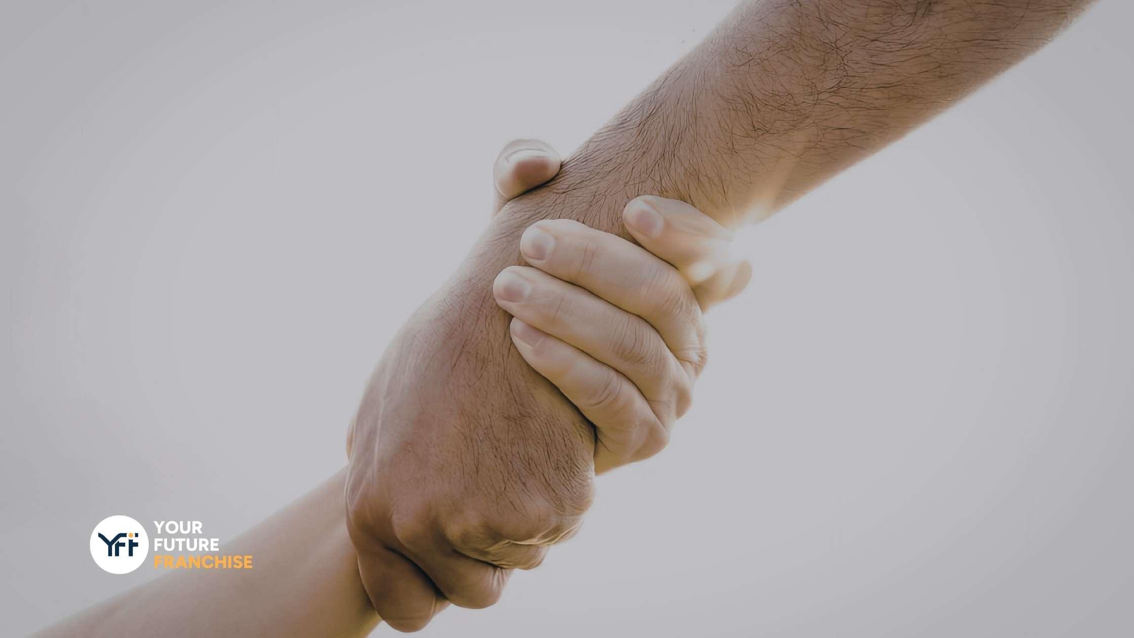 Two hands pulling each other up