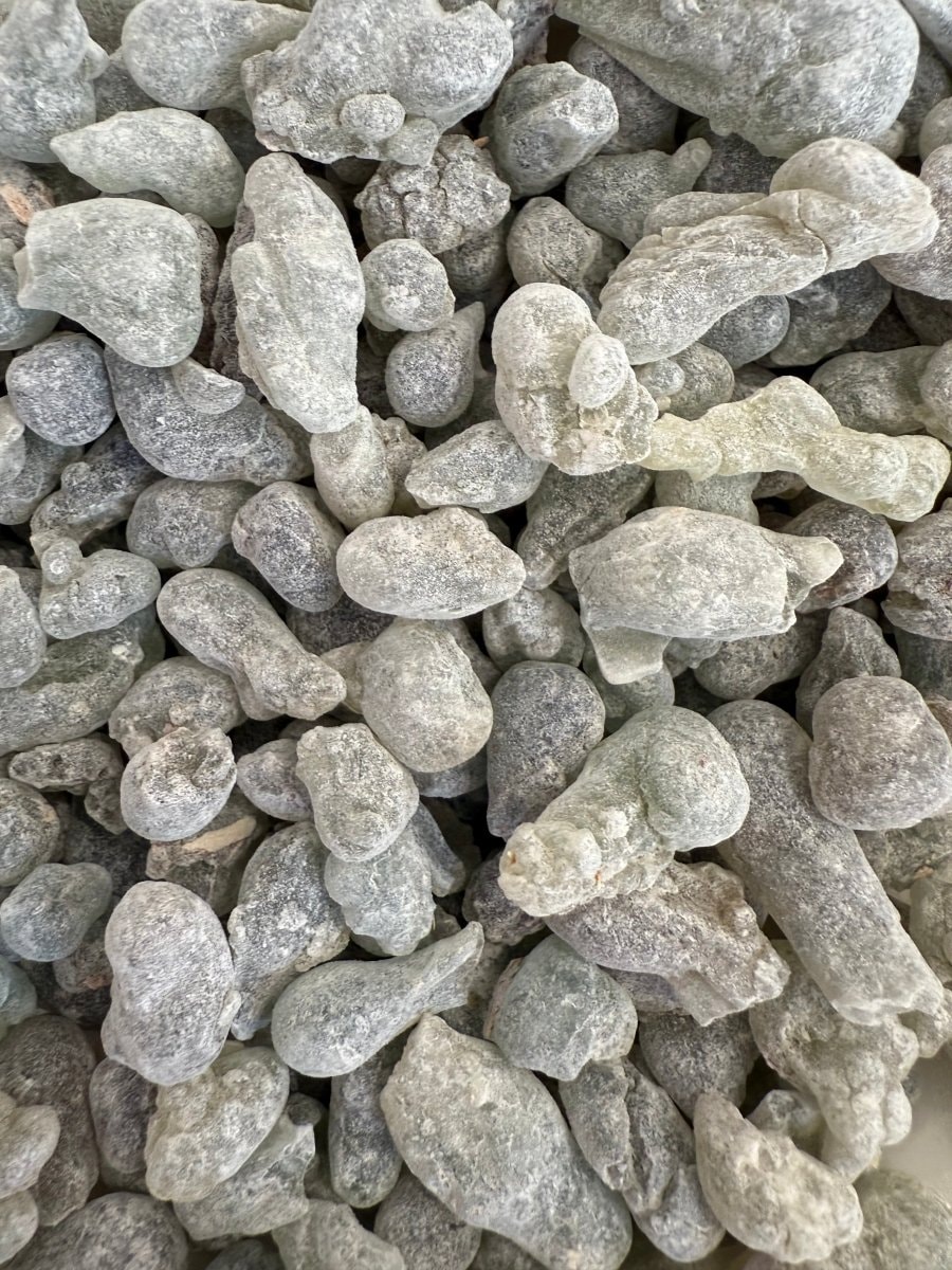 A close-up view of Sultan's Grade frankincense tears showcases a stunning array of colors, ranging from green to ivory white, with marbled clarity that highlights their unique quality. These rare resin pieces, sourced from the boswellia sacra tree, are considered a majestic treasure in the world of incense.