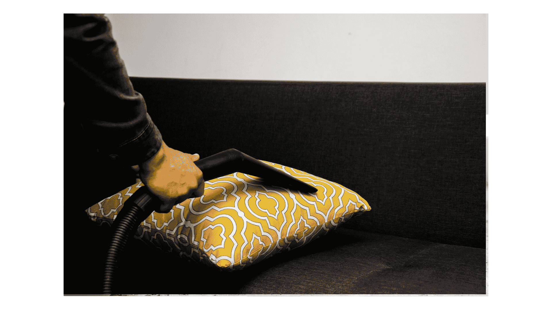 yellow cushion on a black sofa bring dry cleaned