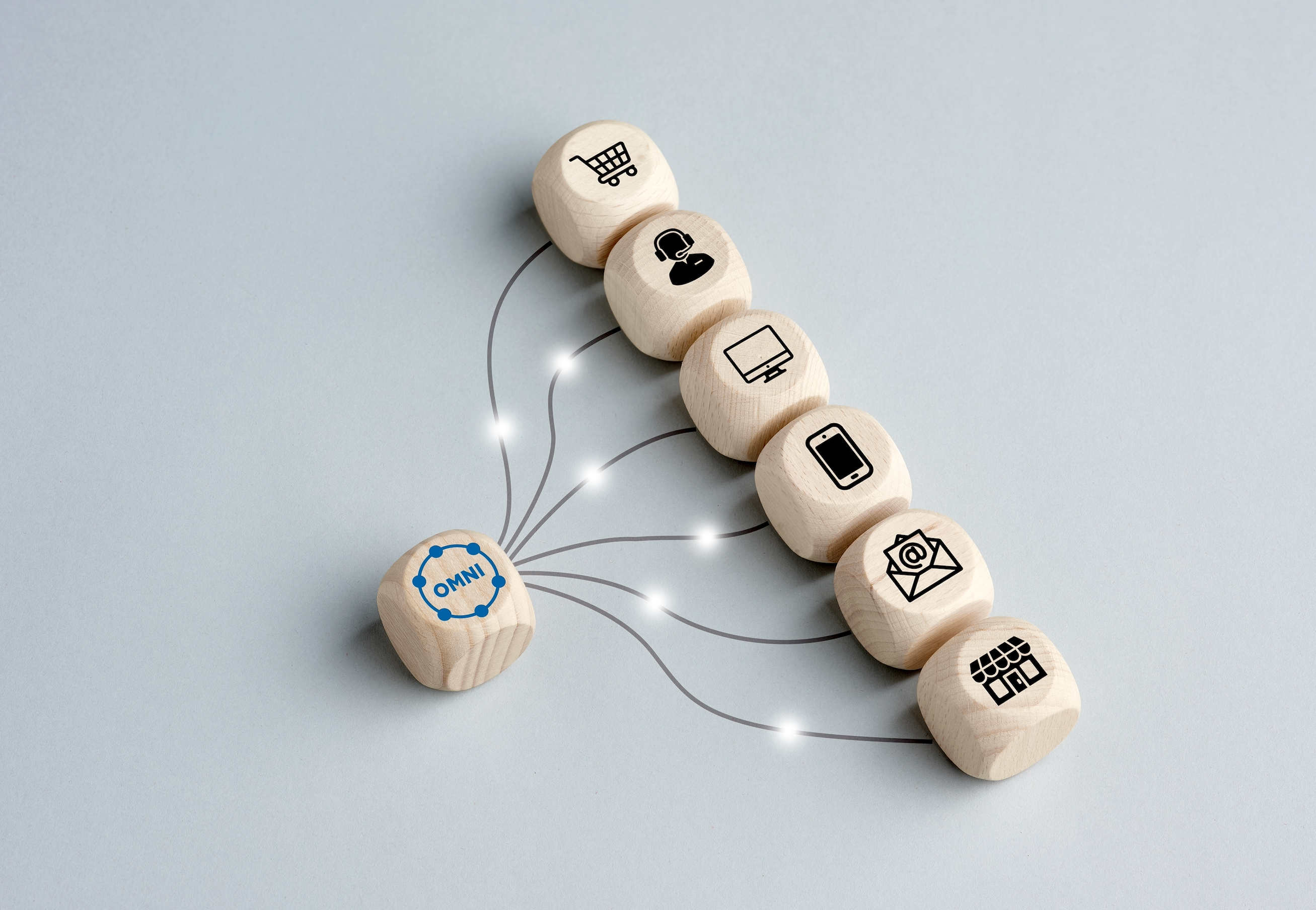a row of wooden blocks with black marketing icons all connect back to one wooden block with the word omni on it