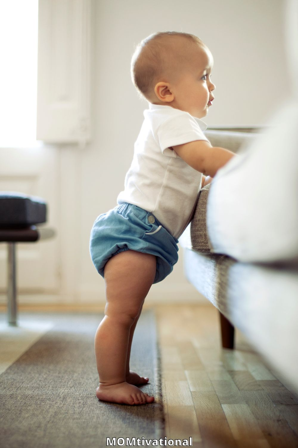 Little boy standing up near a couch