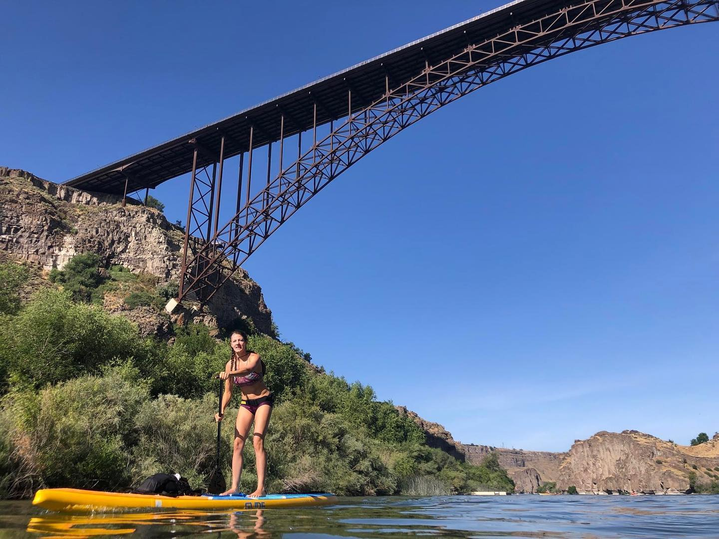 knees slightly bent on an inflatable paddle board