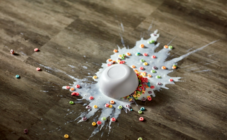 bowl of cereal and milk spilled on floor