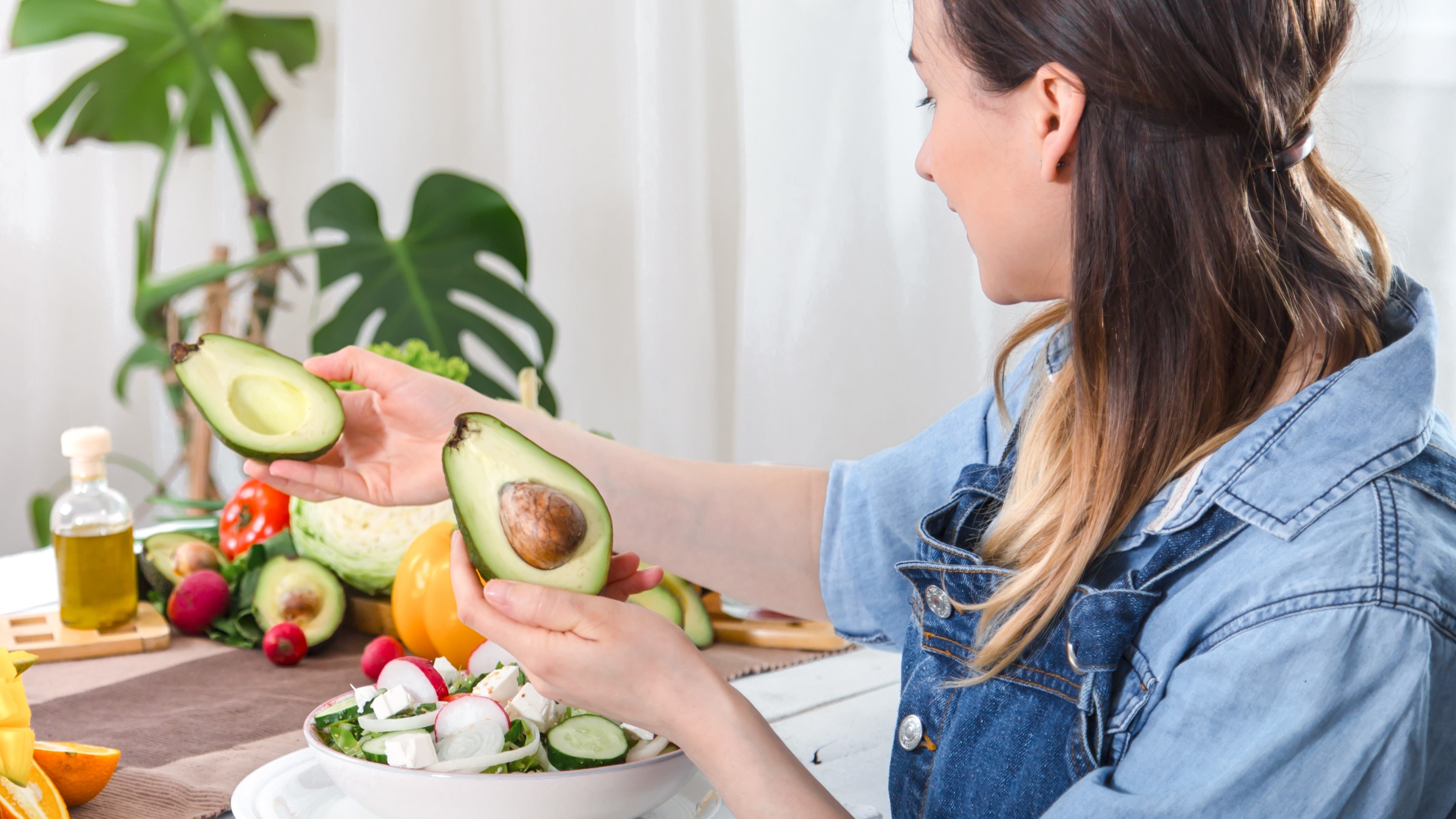 Mimo że istnieją przeciwwskazania dieta ketogeniczna to popularny sposób odżywiania, choć przed rozpoczęciem diety keto najlepiej skonsuktować się z lekarzem. Na zdjęciu kobieta na keto diecie przygotowuje awokado.