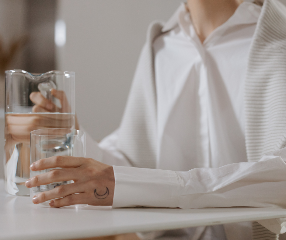 A person's hand holding a glass of water, symbolizing the decision to start quitting drinking after 20 years and embark on a journey of personal growth.