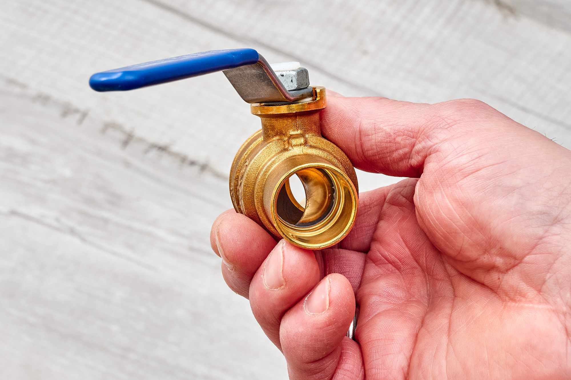 Hand holding water shutoff valve
