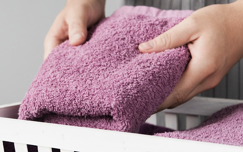 Person storing purple microfiber towel