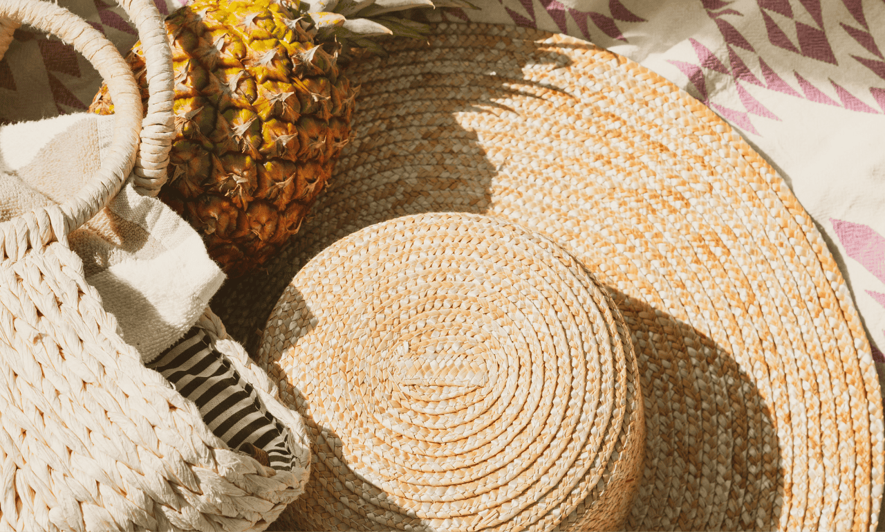 A hat bag and pineapple sitting next to each other.