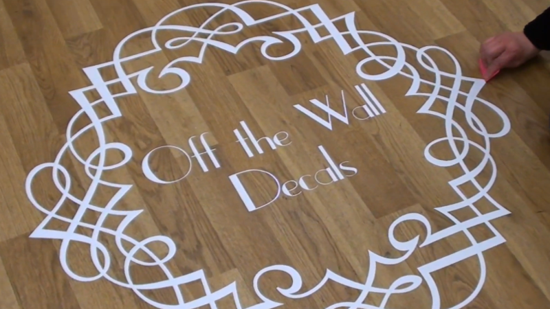Using a plastic scraper to remove floor decal
