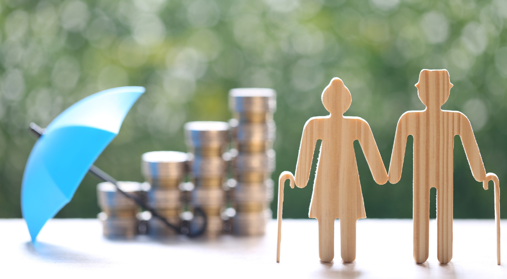 A woooden couple toy in front of coin stack