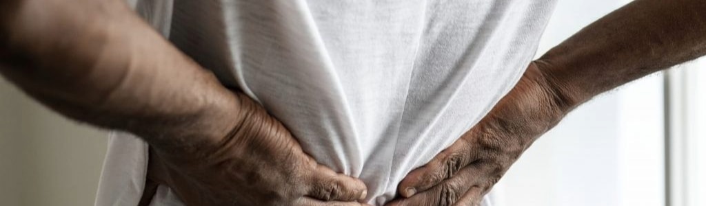 image of a man holding his back in pain.