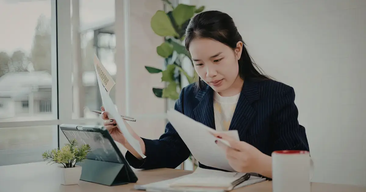 Woman reviewing IRS NFTL documents and financial records to understand tax lien withdrawal options for unpaid tax debt.