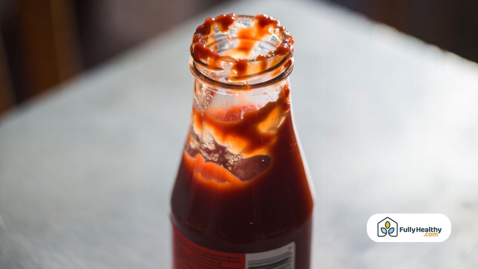 Close-up of opened ketchup bottle showing residue around neck.