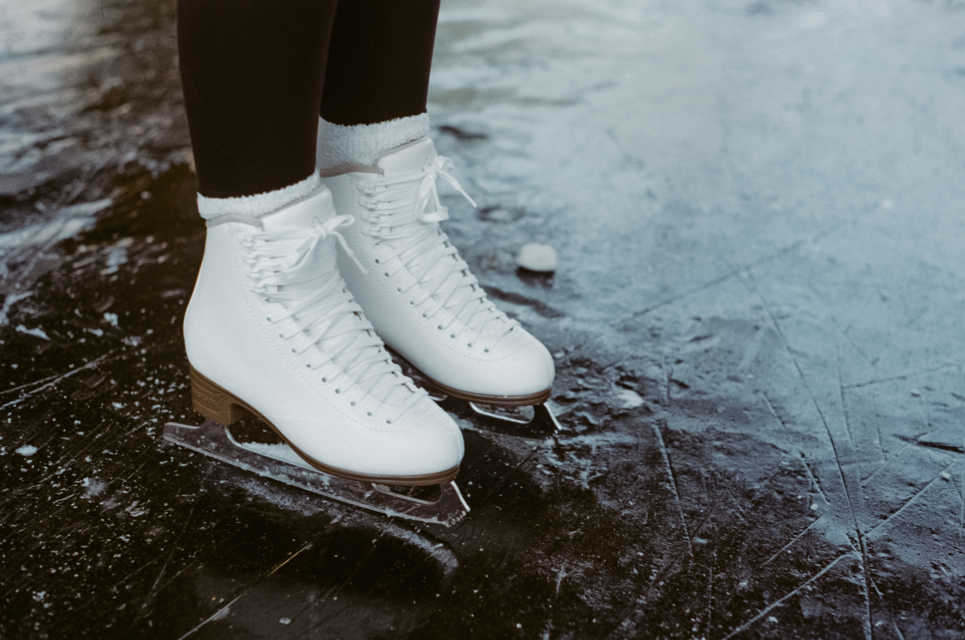 picture of someone on ice skates in ice but only showing their shoes 