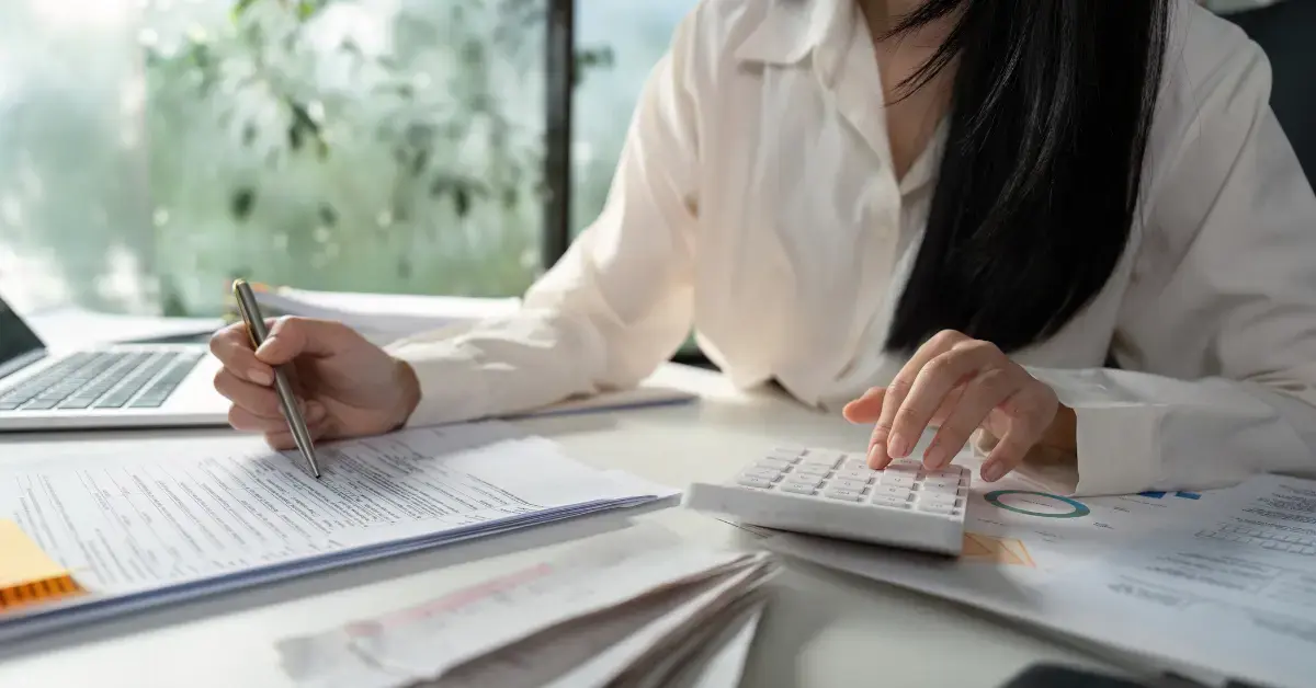 Woman organizing business receipts and preparing documents for 1120 and 1120S tax filing.