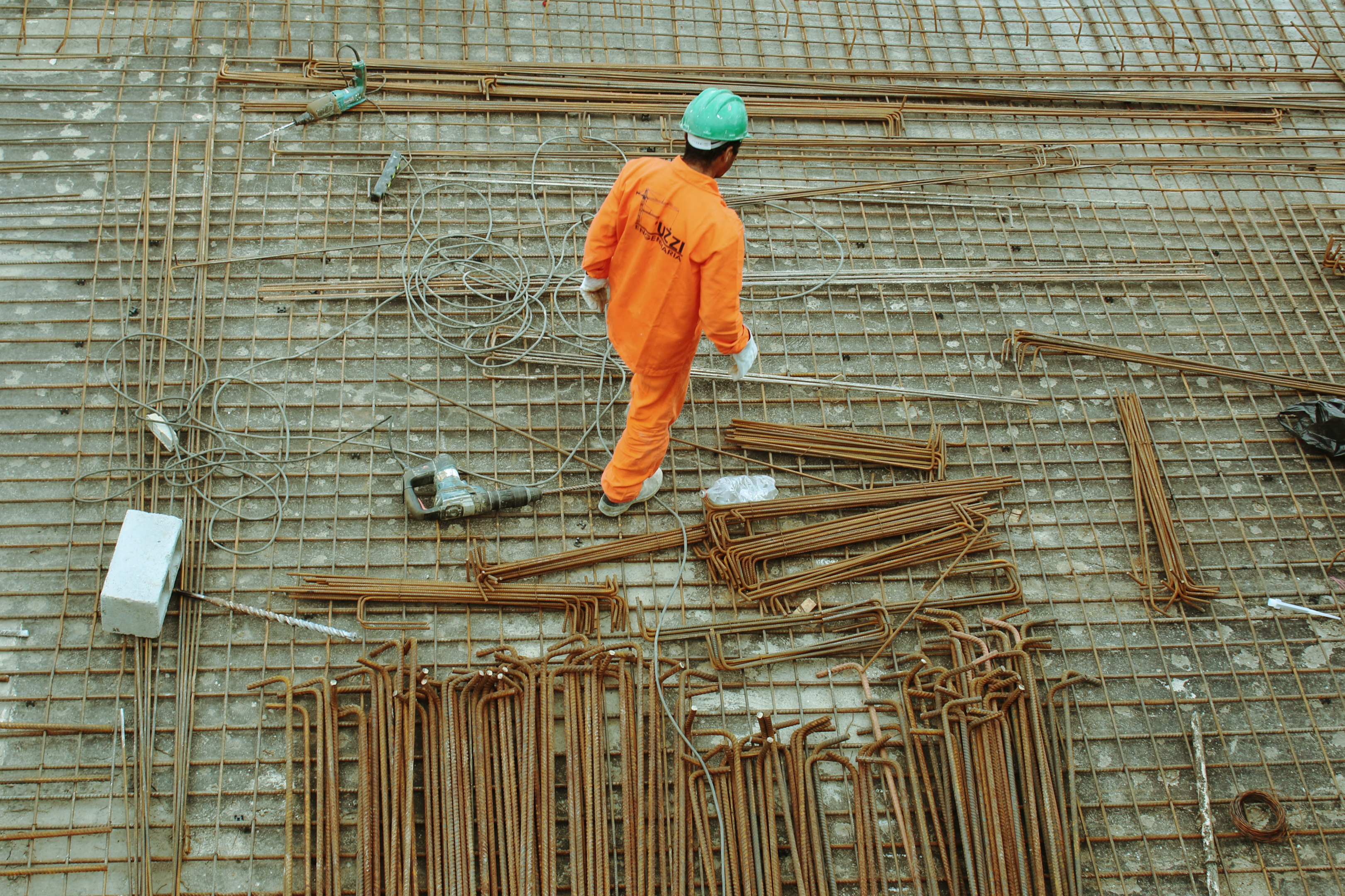 Photo of construction worker standing above the metal rods