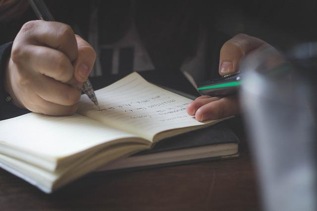 a man writes something in a notebook