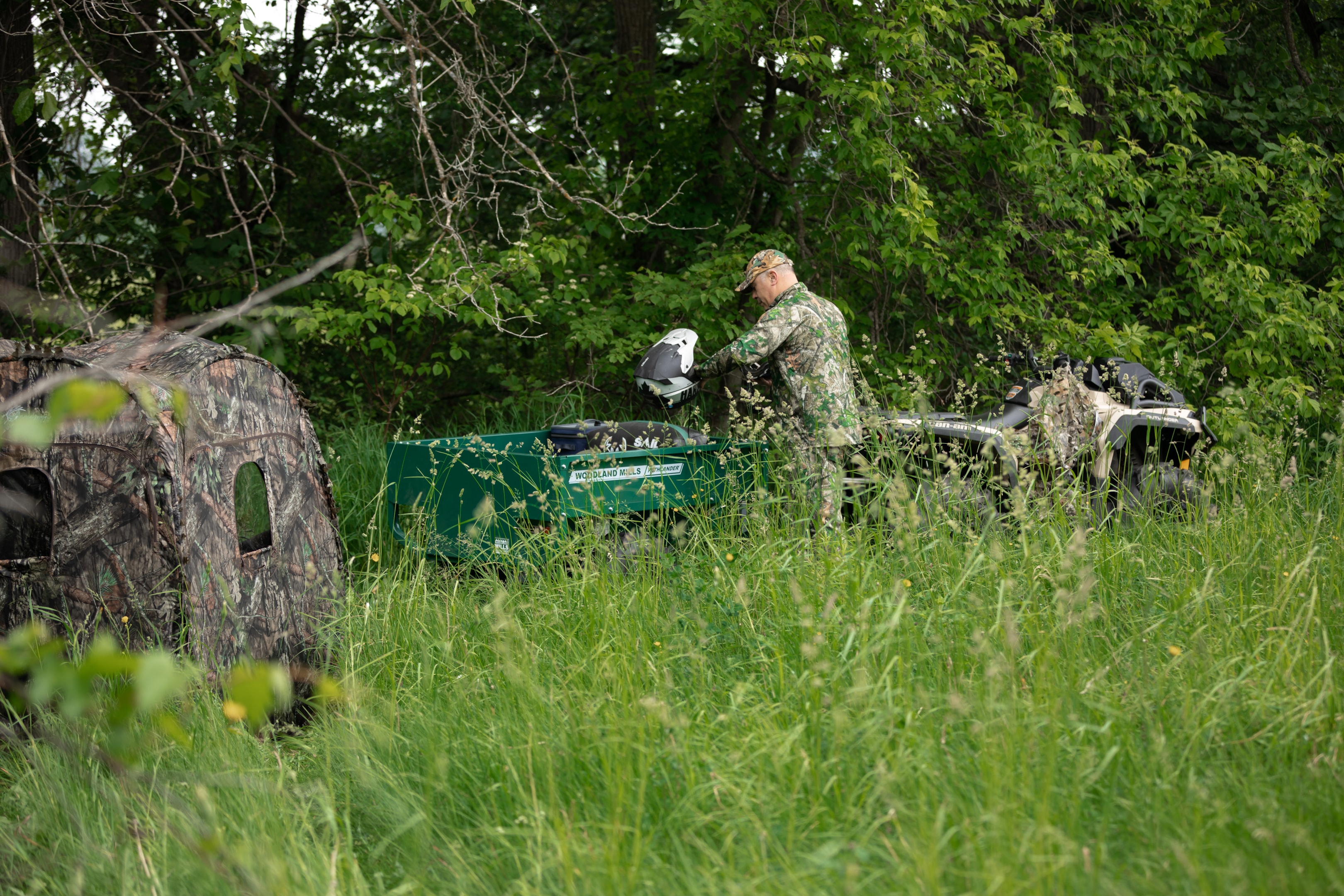 Un chasseur rangeant ses affaires dans sa remorque Woodland Mills Pathlander ATV Trailer pour plus de commodité. 
