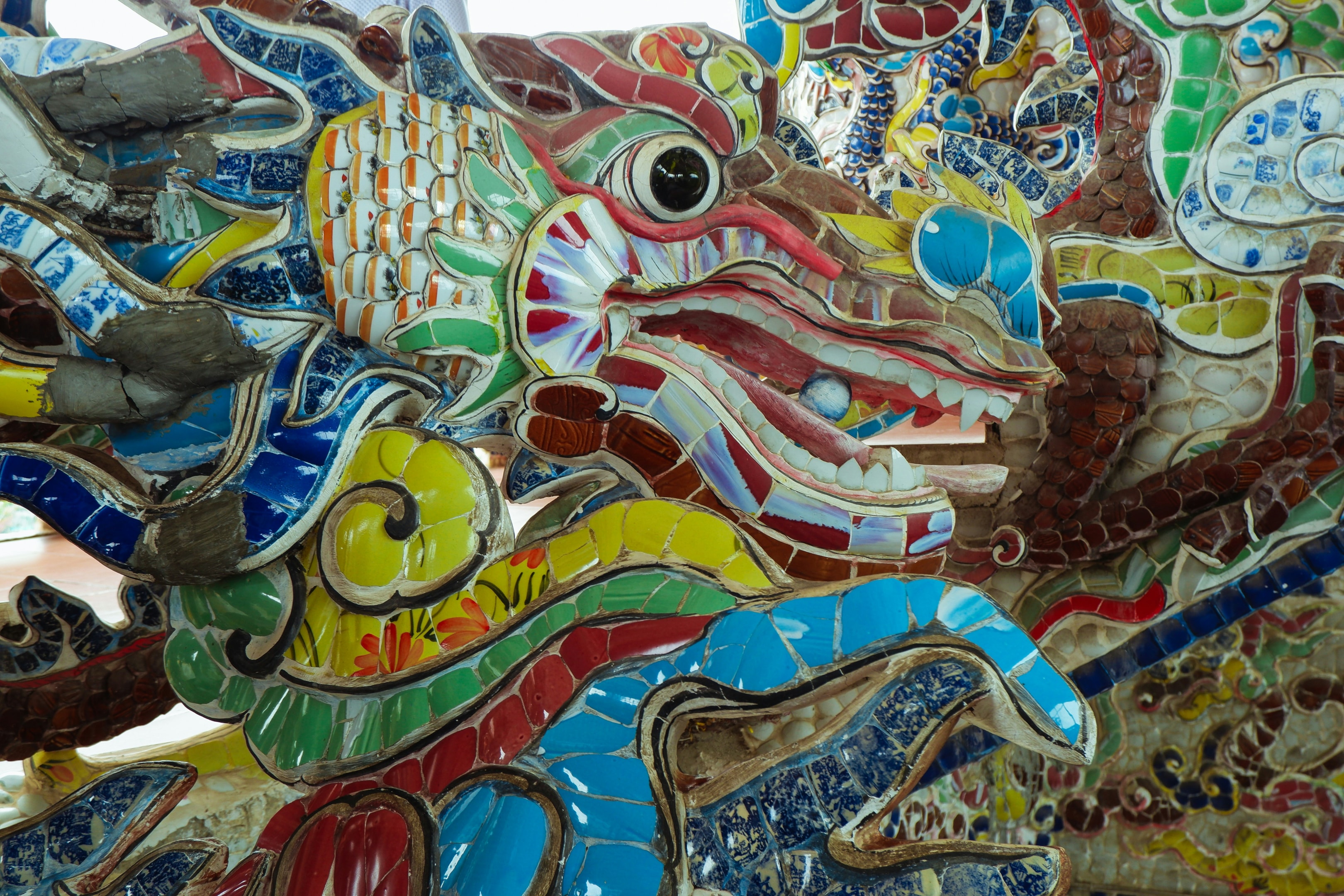 Anthropomorphic Aboriginal artwork: a green, yellow, and blue dragon.