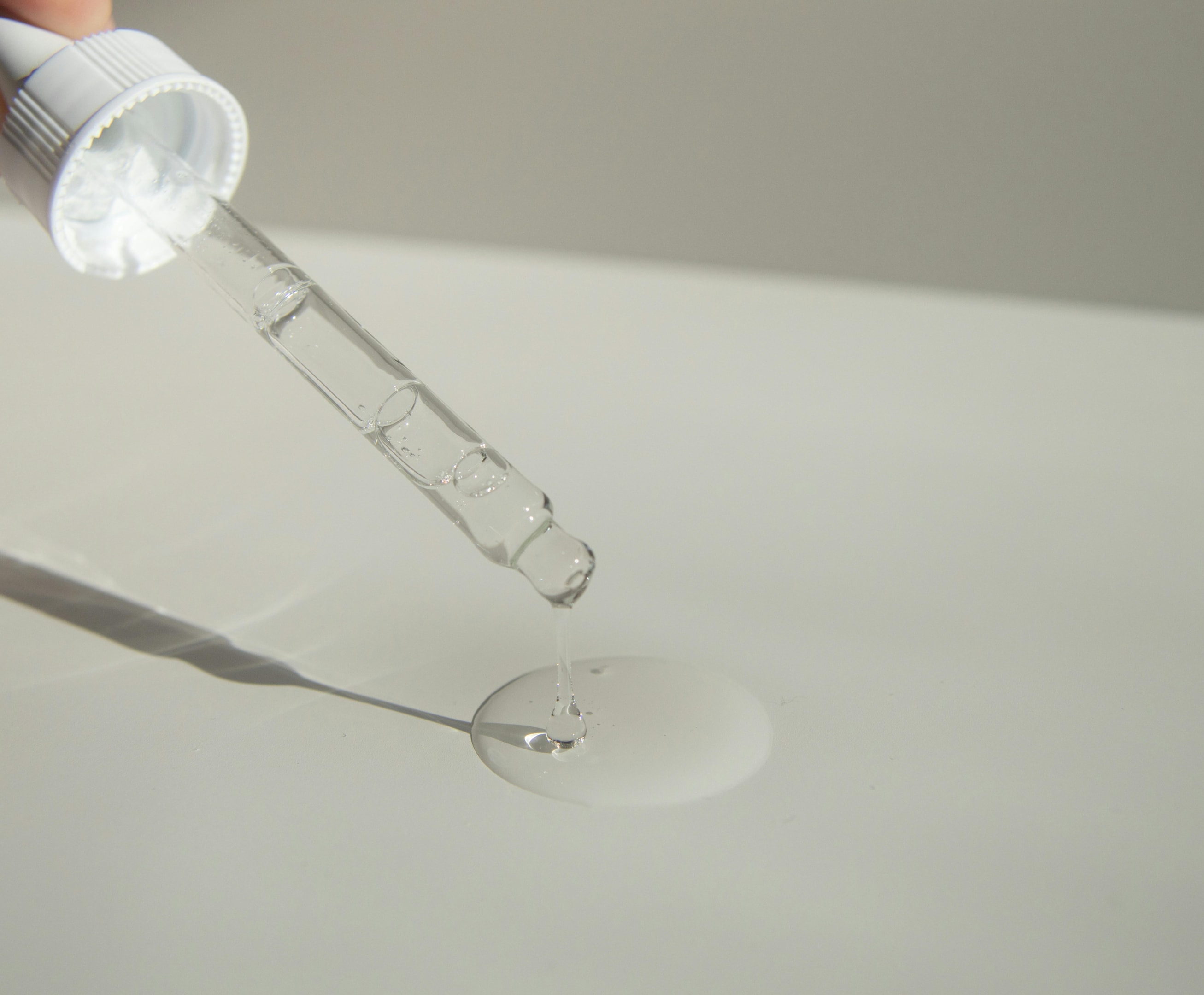 Closeup of a serum applicator being used on a table
