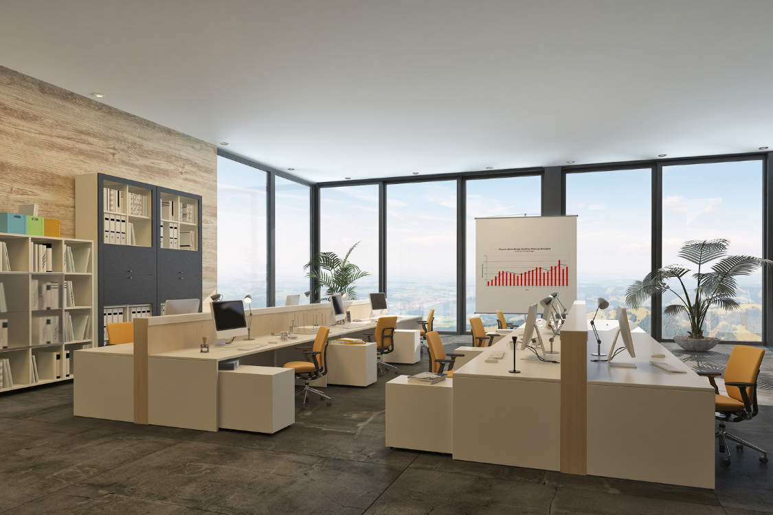 Bright open-plan office space with desks and computers overlooking a city view