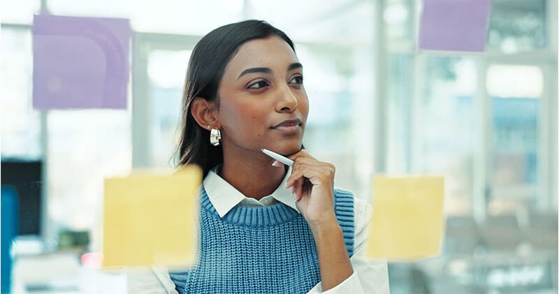 Woman reviewing posted notes illustrating how Quibi failed the strategic decision-making ARC test.