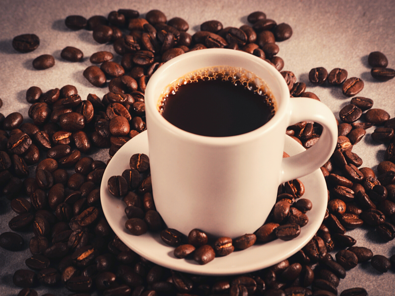 Xicara de café cercada por grãos. Foto: 18447160 para Pixabay.
