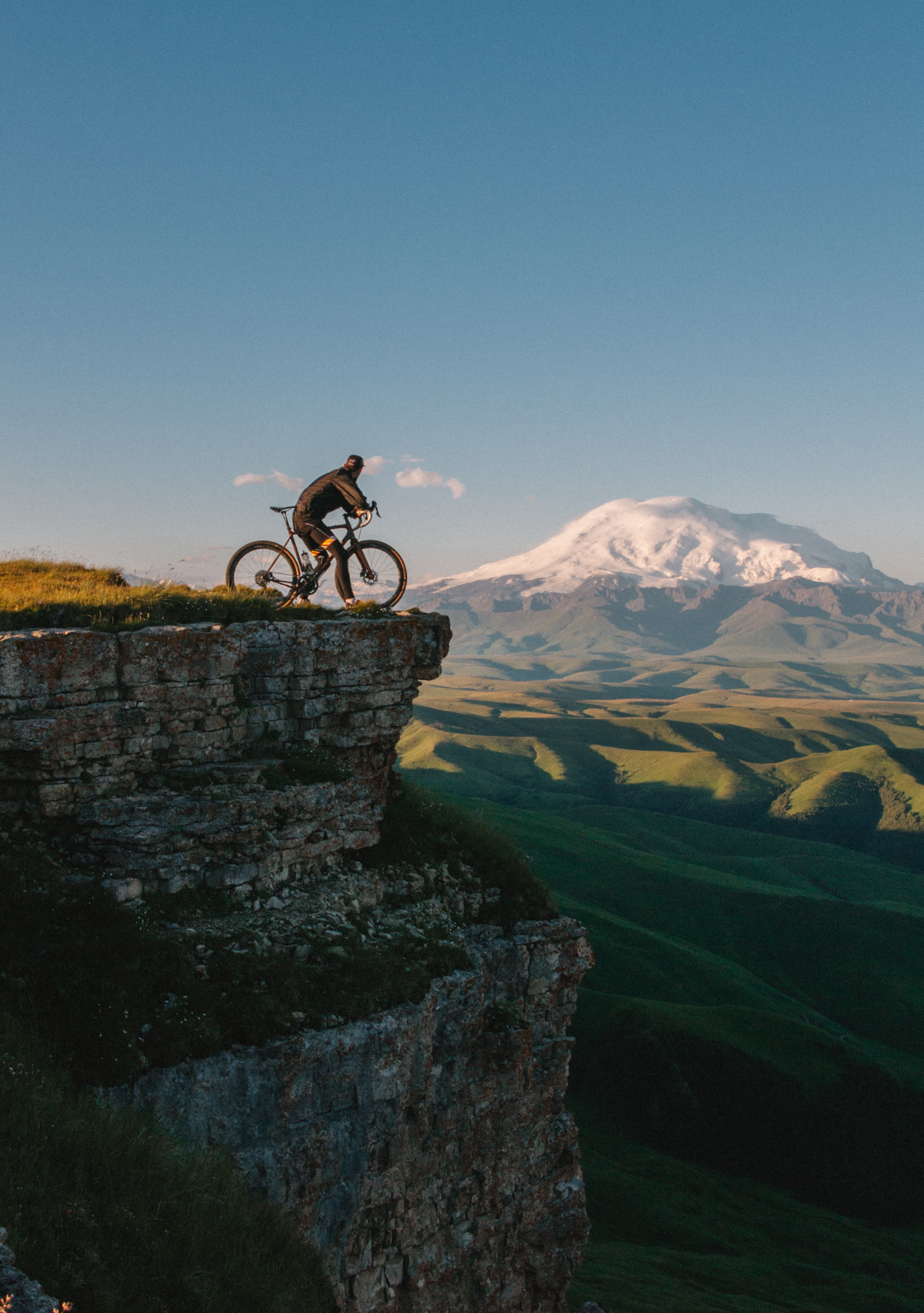 Ciclista apreciando a vista para a montanha. Créditos: Unsplash
