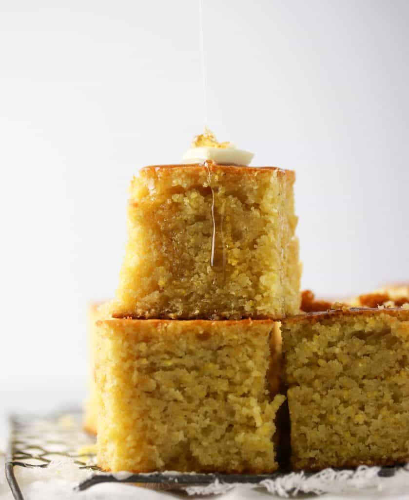 two pieces of cornbread stacked with honey butter on top