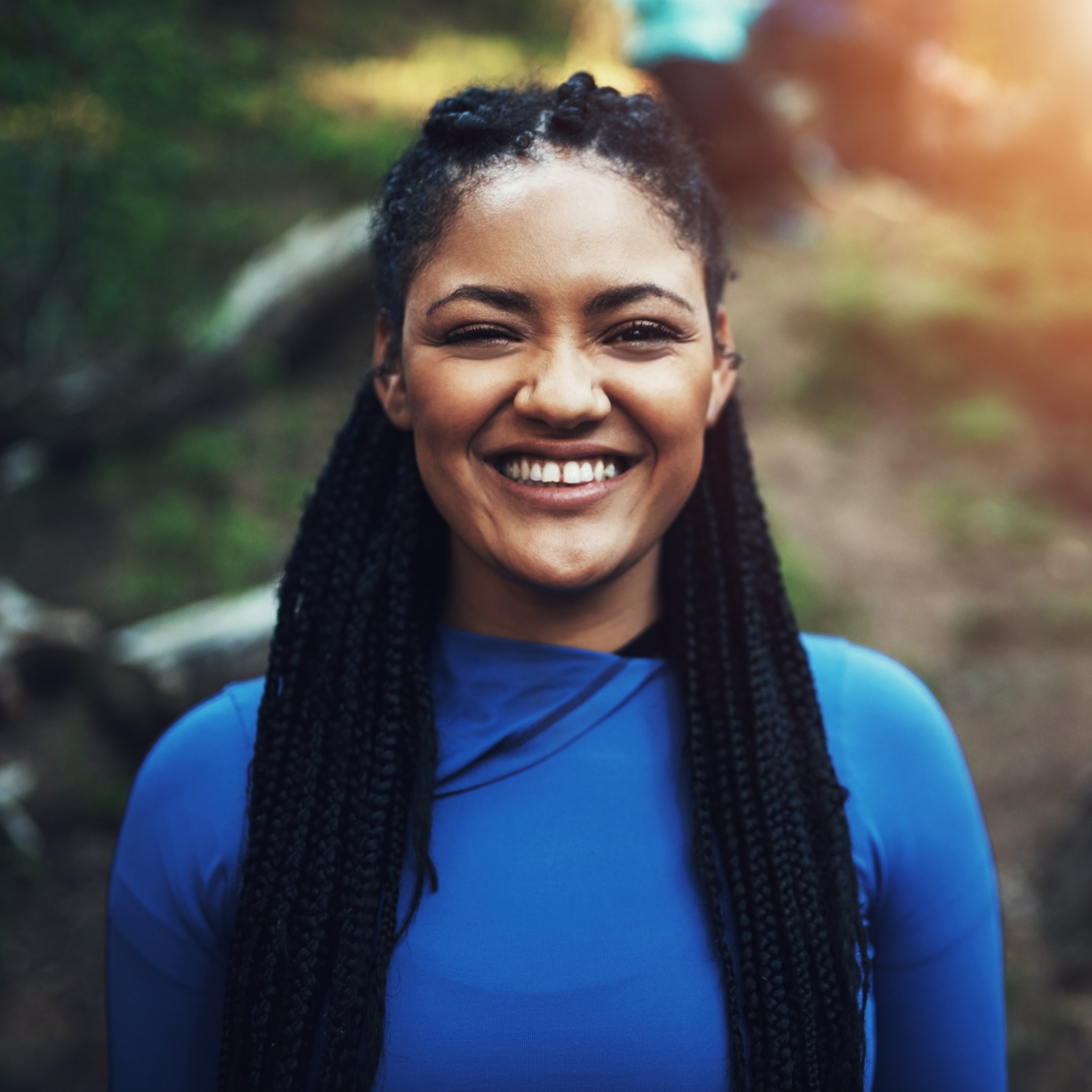 a smiling woman who has gone through dental implant surgery to replace missing teeth