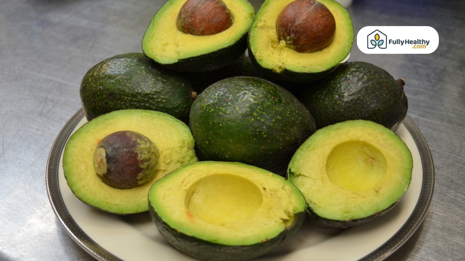 Plate of halved and whole avocados showing green creamy texture