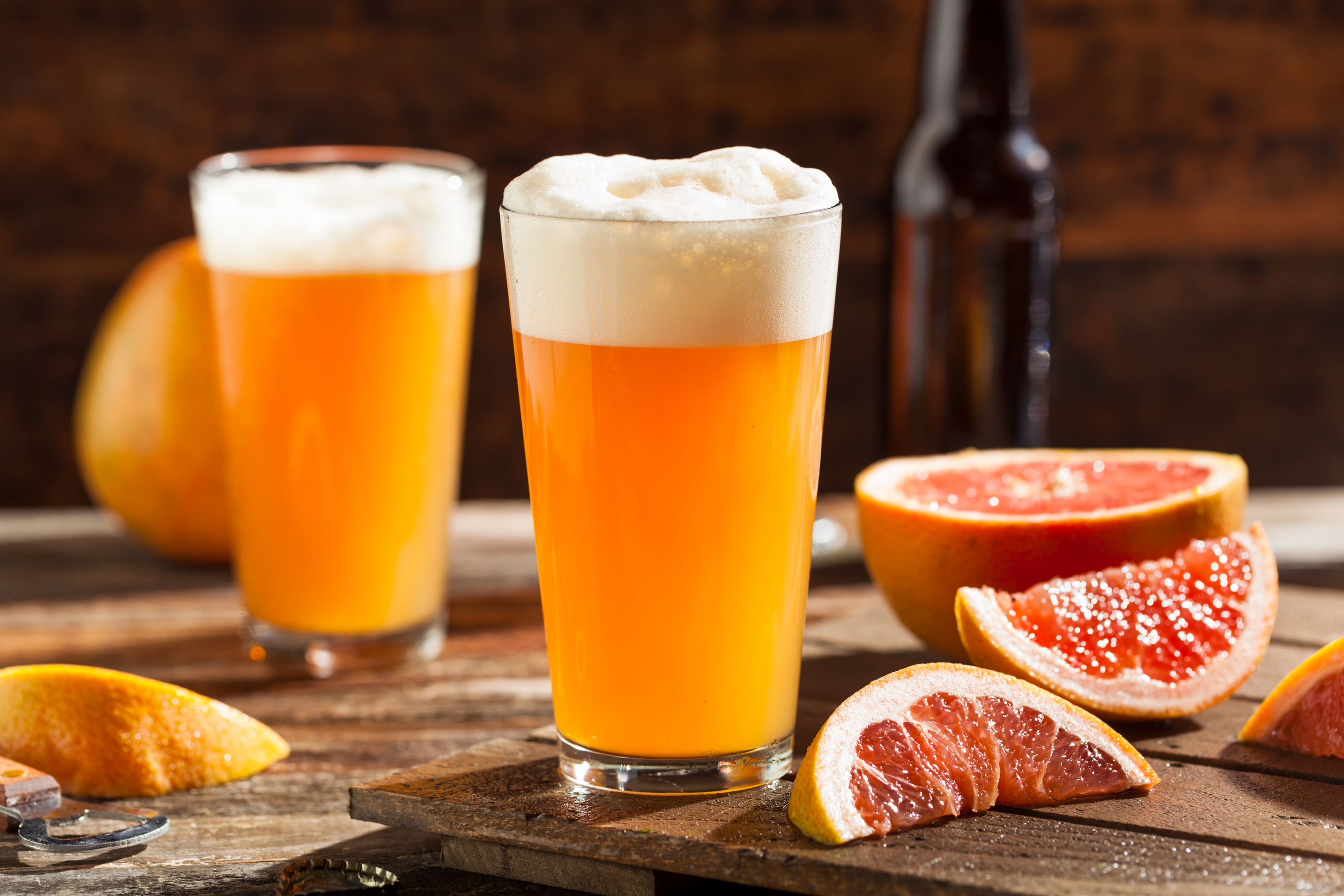 a sour ale with grapefruit slices on a wooden table with a wooden board, an example of what you can order at Charleston South Carolina breweries 