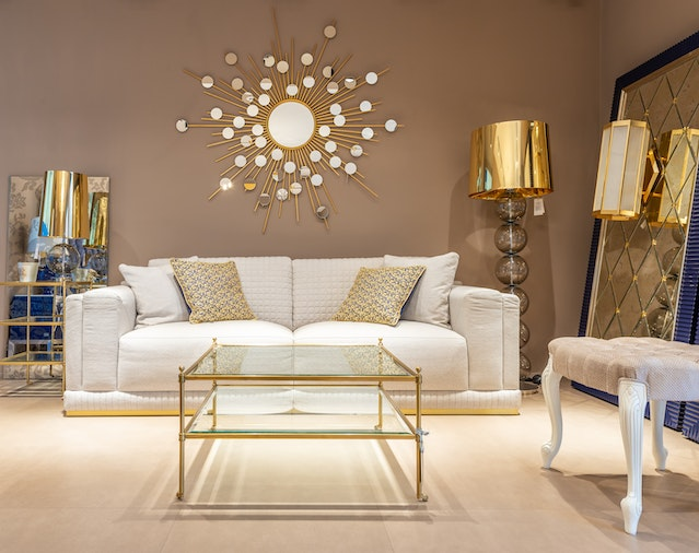 off-white sofa with gold coffee table, large gold lamp, and gold mirror - image credit: https://www.pexels.com/photo/couch-near-table-in-room-7535043/