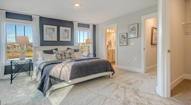 In the image, a modern build-to-rent community features the interior of a home surrounded by landscaped grounds and shared outdoor amenities such as fitness centers and dog parks, showcasing the appeal of multifamily construction projects. The design emphasizes communal spaces that enhance the living experience for multiple tenants within a well-planned residential environment.