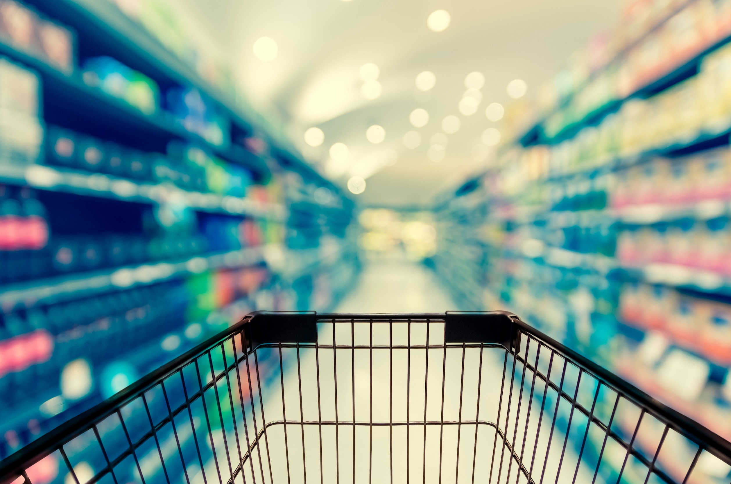 A wire shopping cart in front of a rack of defective products