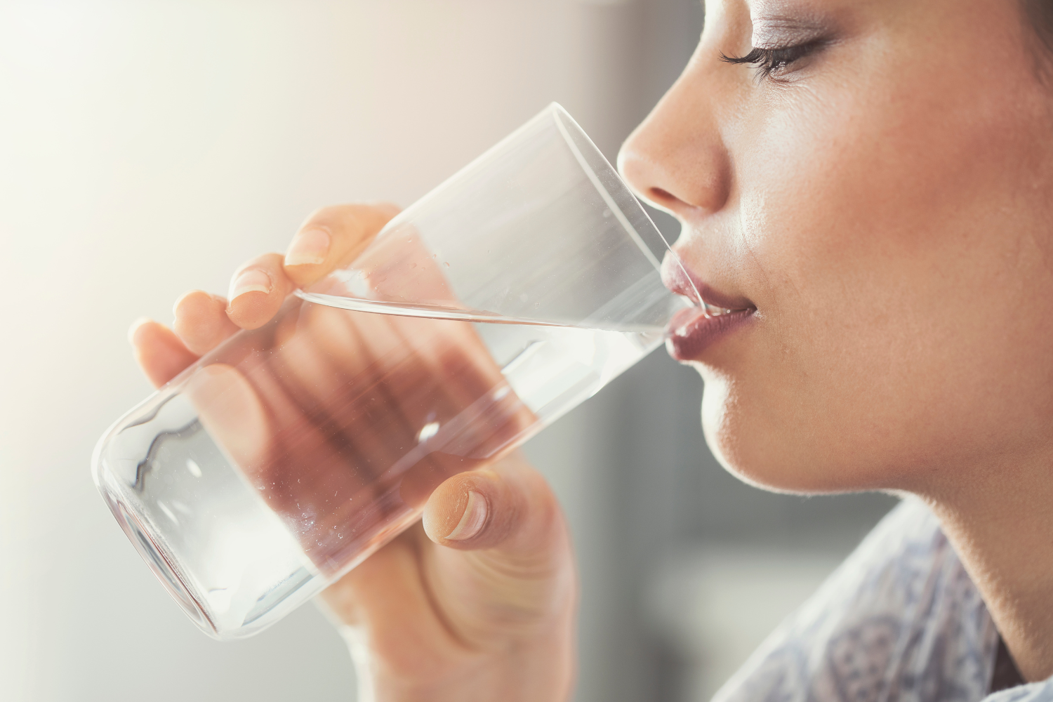 A woman drinking a glass of water.