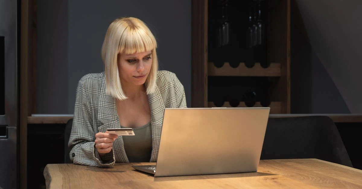 Checking credit card on laptop in home office while learning how do I pay myself from my LLC.