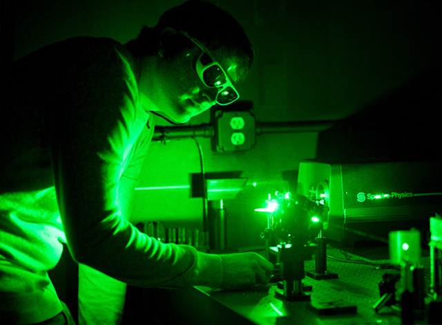 Scientist working with laser wearing proper safety gear