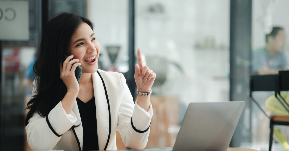 A businesswoman enthusiastically talking on the phone, representing OnlyFans tax compliance services.