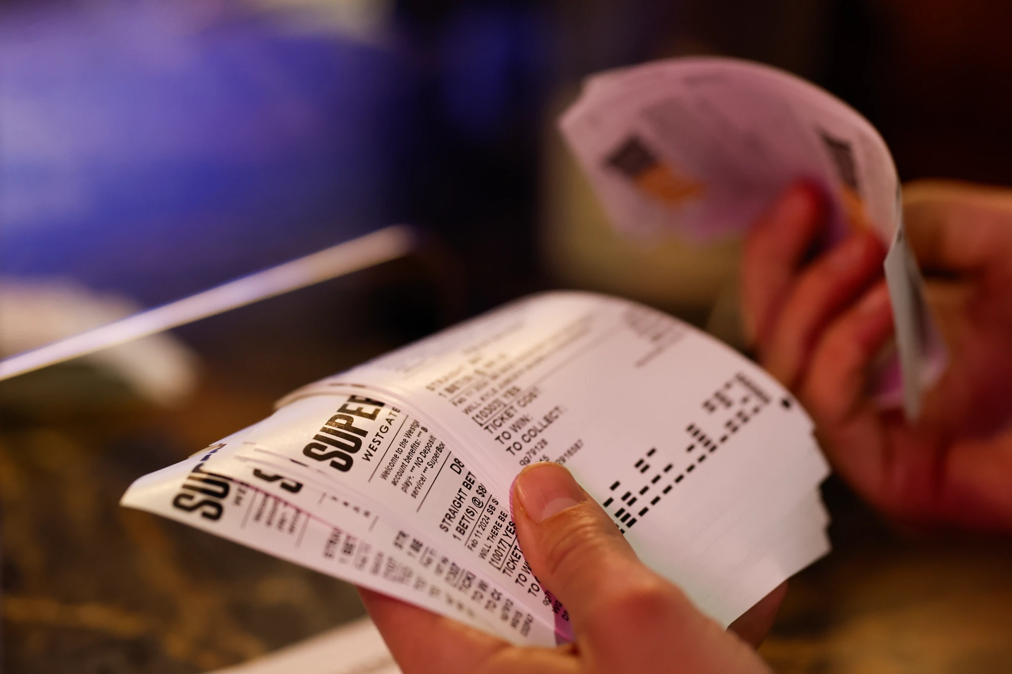 A better looks over their Super Bowl parlay betting slip tickets at the Westgate Superbook sports book ahead of the Super Bowl 58 between the Kansas City Chiefs and the San Francisco 49ers on February 09, 2024 in Las Vegas, Nevada.