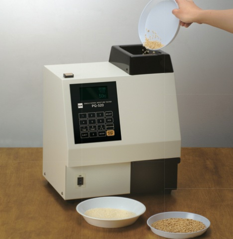 A grain moisture tester being used to measure the moisture content of a grain sample