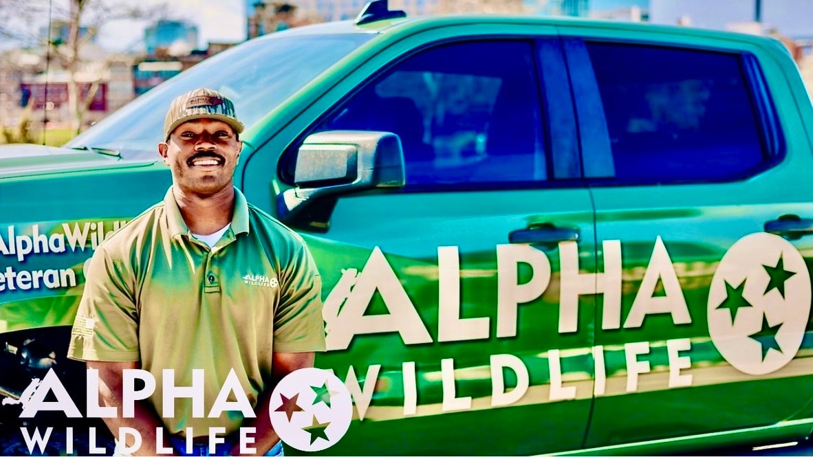 Alpha Wildlife technician standing in front of his truck