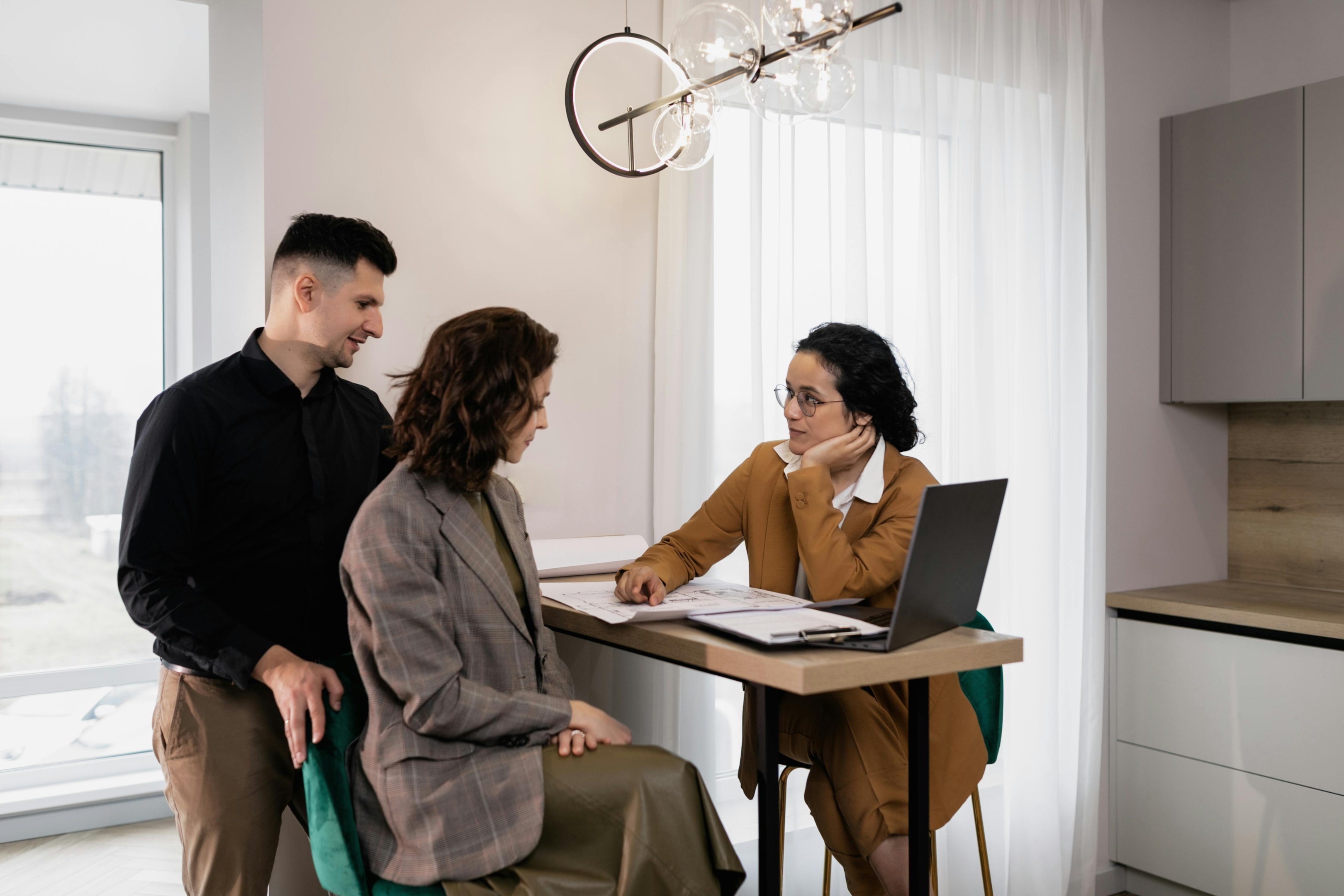 Real estate investor reviews paperwork with motivated home sellers at their property.