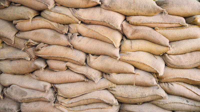 A large pile of sand jute bags sitting on top of each other