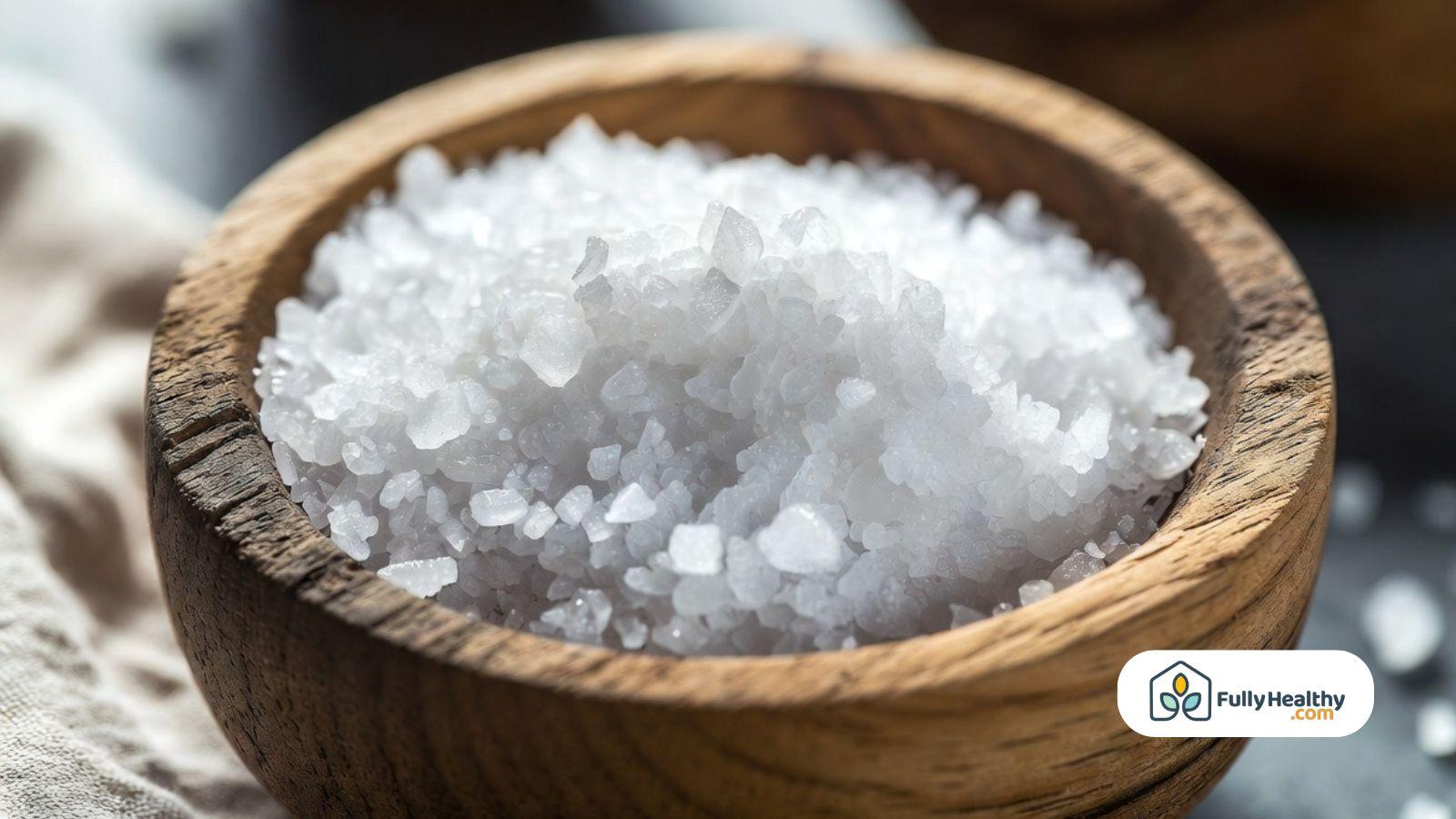Wooden bowl filled with coarse sea salt crystals for everyday cooking.