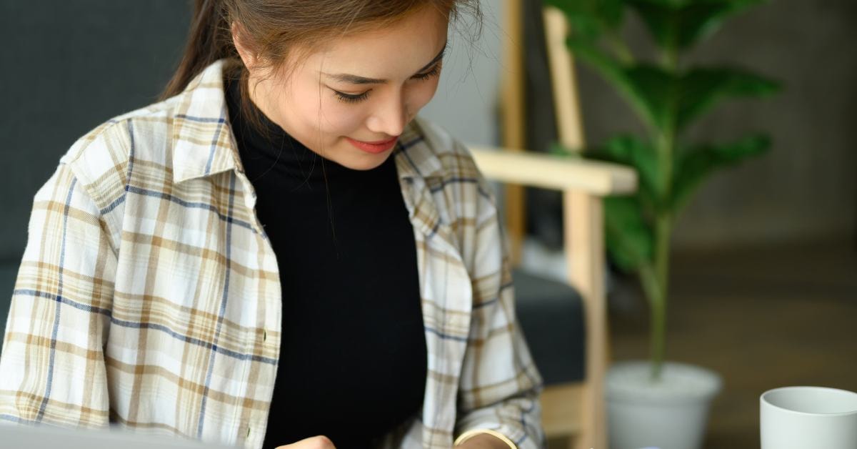 Woman focusing on tax planning strategies while reviewing financial papers at her desk.